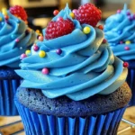 Vibrant and fun blue cupcakes decorated with frosting, sprinkles, and fresh berries.