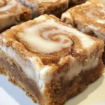 Delicious cinnamon roll blondies drizzled with icing on a rustic plate