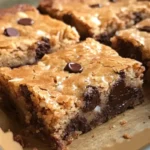 Dark chocolate coconut blondies fresh out of the oven on a wooden table